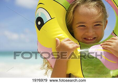 Stock Photo - Hawaii, Oahu, Little Girl Poses On Beach With Tube.. Fotosearch