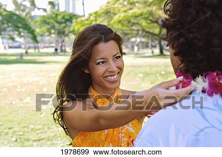 Hawaii, Oahu, Local Girl Wearing A Pareo Places A Lei Around A Mans Neck. View Large Photo Image Stock Photo - Hawaii, Oahu, Local Girl Wearing A Pareo Places A Lei Around A Mans Neck.. Fotosearch