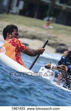 Stock Image - Hawaii, Oahu, Makaha, Close-Up Of Man Steering Canoe While Surfing Wave. No Model Release. Fotosearch