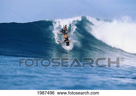 Stock Photograph - Hawaii, Oahu, Makaha, Frontal View Of Men In Outrigger Canoe Surfing Large Wave. No Model Release. Fotosearch