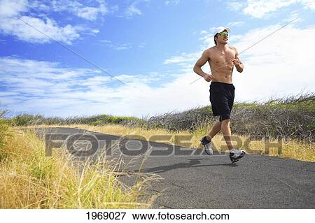 Stock Photo - Hawaii, Oahu, Makapu'u, Athletic Male Running Along The Makapuu Hiking Trail. Fotosearch