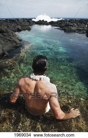 Picture - Hawaii, Oahu, Makapuu, Attractive Male Wearing A Lei Sitting In A Beautiful Tidepool. Fotosearch