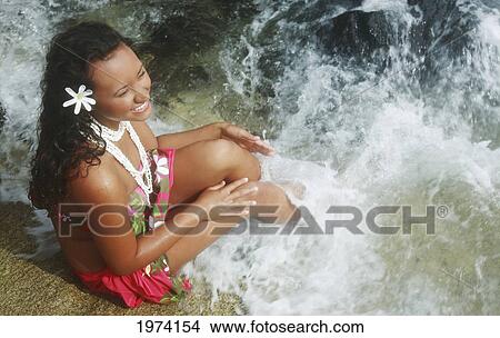Picture - Hawaii, Oahu, Makapuu, Attractive Young Woman On The Rocks With Hawaiiana Attire.. Fotosearch
