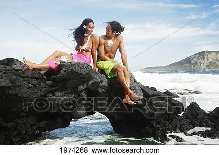 Stock Photo - Hawaii, Oahu, Makapuu, Male And Female Hula Dancers Sit On A Rock Posing.. Fotosearch