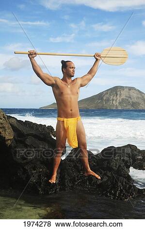 Hawaii, Oahu, Makapuu, Polynesian Man In Traditional Hawaiian Clothing On Rocky Shore Holding A Paddle. View Large Photo Image Stock Photo - Hawaii, Oahu, Makapuu, Polynesian Man In Traditional Hawaiian Clothing On Rocky Shore Holding A Paddle.. Fotosearch