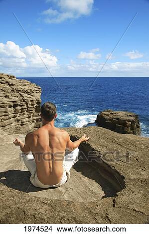 Picture - Hawaii, Oahu, Male Doing Yoga On Rocky Cliff.. Fotosearch