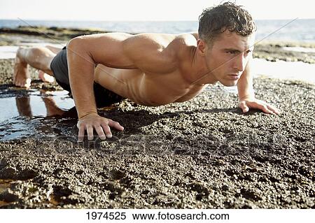 Stock Photography - Hawaii, Oahu, Male Excercising On The Beach.. Fotosearch