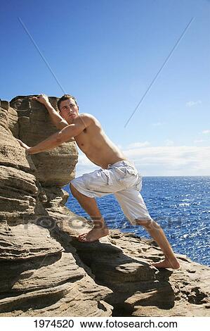 Stock Image - Hawaii, Oahu, Male Rock Climbing.. Fotosearch