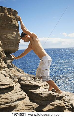 Stock Image - Hawaii, Oahu, Male Rock Climbing.. Fotosearch