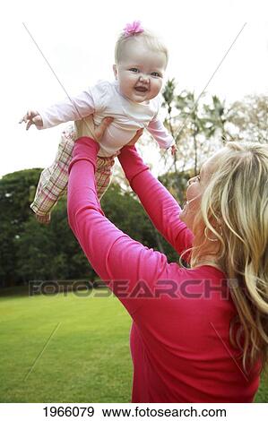 Stock Photo - Hawaii, Oahu, Mother And Baby Girl Play Together In Park.. Fotosearch