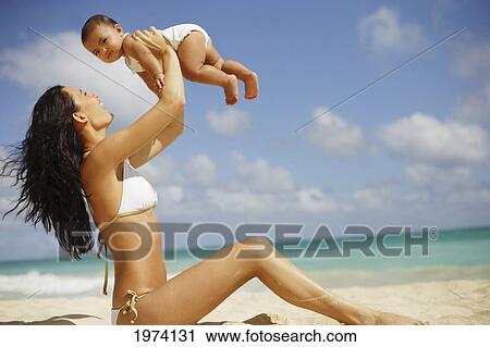 Stock Image - Hawaii, Oahu, Mother And Her Baby Enjoy A Day At The Beach.. Fotosearch