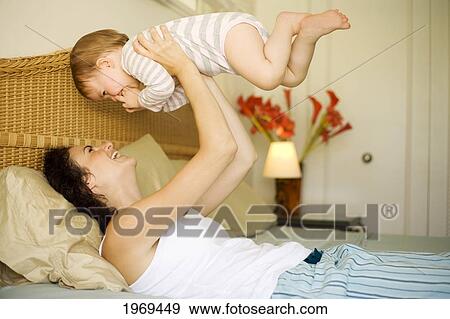 Hawaii, Oahu, Mother And Her Baby On The Bed. View Large Photo Image Stock Photo - Hawaii, Oahu, Mother And Her Baby On The Bed.. Fotosearch