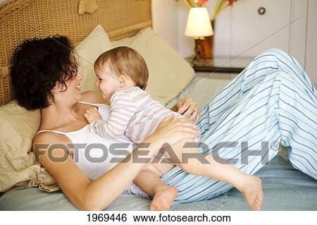 Hawaii, Oahu, Mother And Her Baby On The Bed. View Large Photo Image Stock Photograph - Hawaii, Oahu, Mother And Her Baby On The Bed.. Fotosearch