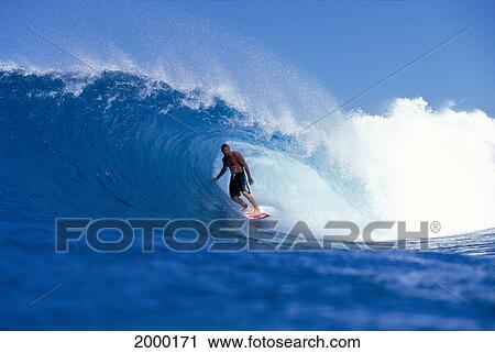 Stock Image - Hawaii, Oahu, North Shore, Backdoor Surfer Stands Inside Wave Curl Blue Sky Background. Fotosearch