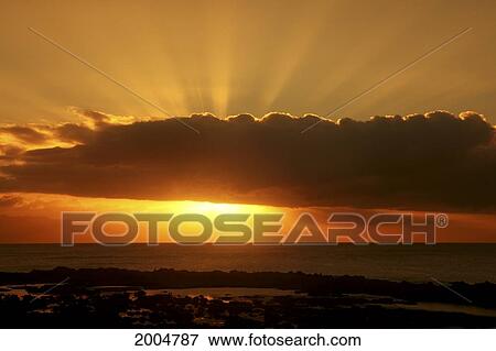Stock Photo - Hawaii, Oahu, North Shore, Dynamic Sunset, Sun Behind Cloud Sending Sunrays Into The Sky.. Fotosearch