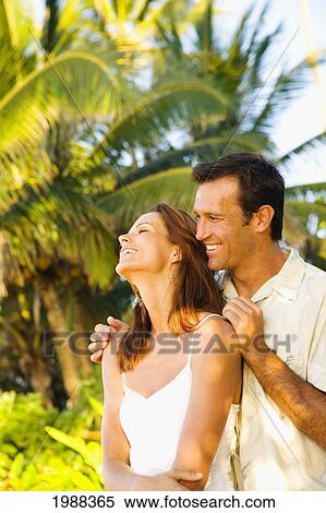 Hawaii, Oahu, North Shore, Happy Embracing On Beach In Warm Afternoon Light, Palm Trees Behind. View Large Photo Image Stock Photography - Hawaii, Oahu, North Shore, Happy Embracing On Beach In Warm Afternoon Light, Palm Trees Behind.. Fotosearch