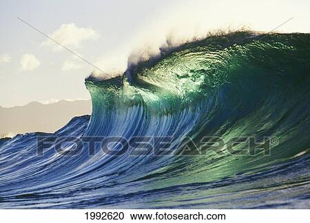 Stock Image - Hawaii, Oahu, North Shore; Large Green Blue Wave About To Curl, Mountains In Background.. Fotosearch