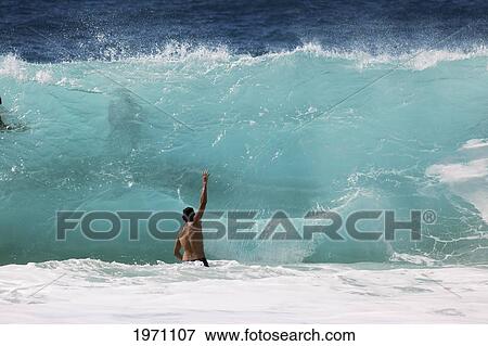 Stock Photo - Hawaii, Oahu, North Shore, Man Faces Giant Wave. (Editorial Use Only).. Fotosearch