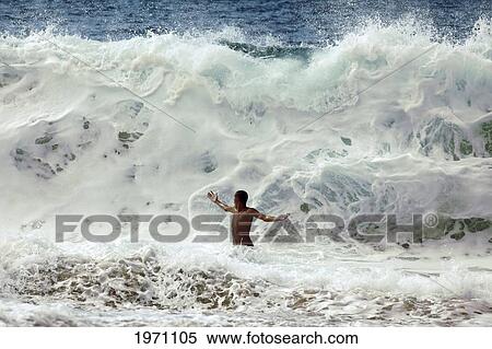 Stock Photography - Hawaii, Oahu, North Shore, Man Is About To Be Crushed By Giant Wave. (Editorial Use Only).. Fotosearch