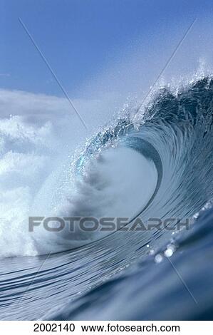 Stock Image - Hawaii, Oahu, North Shore, Pipeline, Side View Of Large Wave Curling, Crystalline Water, Blue Sky Background. Fotosearch