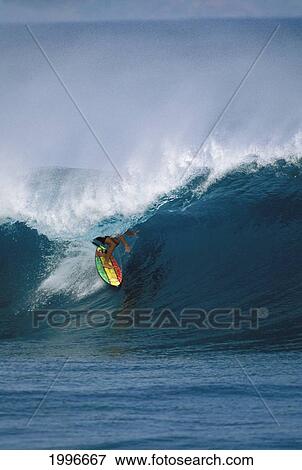 Stock Photo - Hawaii, Oahu, North Shore, Pipeline, Surfer Rides Tube Under Curl On Rasta Colored Board. Fotosearch