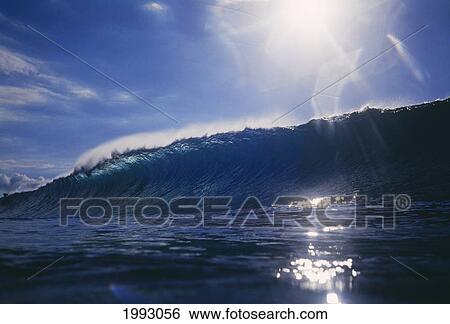 Stock Photograph - Hawaii, Oahu, North Shore, Pipeline Wave, Sunburst Above.. Fotosearch