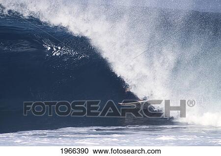 Stock Image - Hawaii, Oahu, North Shore, Surfer Nearly Hidden Inside A Wave.. Fotosearch