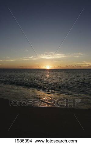 Picture - Hawaii, Oahu, North Shore, Water Lapping Onto Shore Of A Beautiful Sandy Beach At Sunset.. Fotosearch