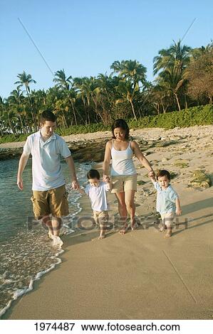 Stock Photo - Hawaii, Oahu, North Shore, Young Family Holding Hands Strolling Along The Beach.. Fotosearch
