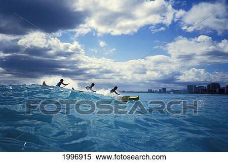 Stock Photography - Hawaii, Oahu, Outrigger Canoe Surfing Wave, Waikiki, Buildings, Clouds. Fotosearch