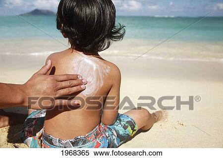 Hawaii, Oahu, Parent Putting Sunscreen Lotion On Child's Back At The Beach View Large Photo Image Stock Photography - Hawaii, Oahu, Parent Putting Sunscreen Lotion On Child's Back At The Beach. Fotosearch