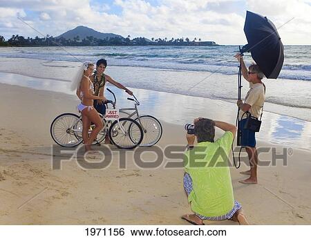 Stock Photograph - Hawaii, Oahu, Photographer Shooting A Portrait Session On The Beach. Fotosearch