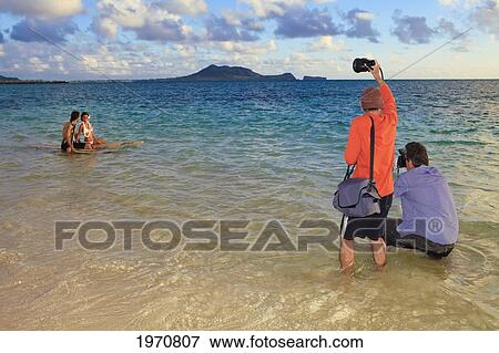 Stock Photo - Hawaii, Oahu, Photoshoot In The Ocean At Sunset. Fotosearch