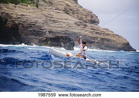 Hawaii, Oahu, Portlock, Girl Racing One-Man Outrigger Canoe, View From Front, Layered Rocky Cliffs In Background. No Model Release View Large Photo Image Stock Photo - Hawaii, Oahu, Portlock, Girl Racing One-Man Outrigger Canoe, View From Front, Layered Rocky Cliffs In Background. No Model Release. Fotosearch