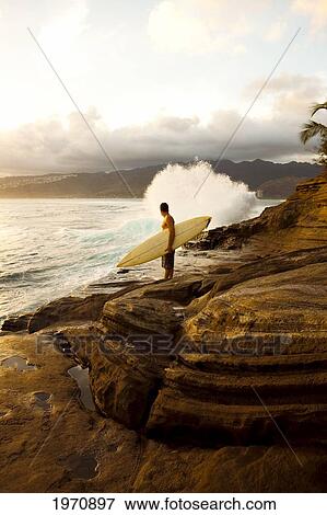 Stock Photo - Hawaii, Oahu, Portlock, Male Surfer Admires View From China Walls. (Editorial Use Only). Fotosearch