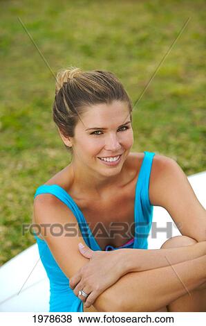 Stock Photo - Hawaii, Oahu, Pretty Girl Sitting On Grass With A Surfboard.. Fotosearch