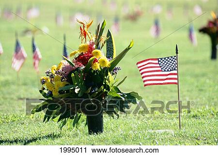 Stock Image - Hawaii, Oahu, Punchbowl National Cemetary Of The Pacific, Closeup Flower Arrangement American Flags. Fotosearch