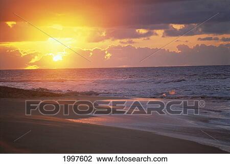 Stock Image - Hawaii, Oahu, Sandy Beach At Sunrise, Glowing Sky, Shoreline A32H. Fotosearch