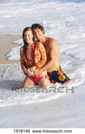 Stock Photograph - Hawaii, Oahu, Sexy Couple Share A Romantic Moment At The Beach.. Fotosearch