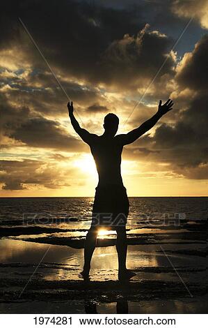 Hawaii, Oahu, Silhouette Of Fit Man Standing On The Rocky Coastline As The Sun Sets. View Large Photo Image Stock Image - Hawaii, Oahu, Silhouette Of Fit Man Standing On The Rocky Coastline As The Sun Sets.. Fotosearch