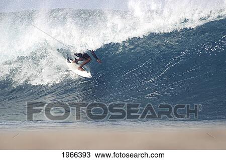 Stock Image - Hawaii, Oahu, Surfer Catching A Wave Near Shore.. Fotosearch