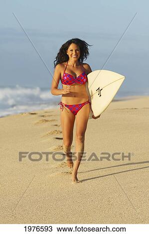 Stock Image - Hawaii, Oahu, Surfer Girl On Beach In Swimsuit With Surfboard.. Fotosearch