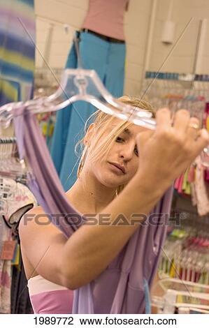 Stock Image - Hawaii, Oahu, Teenage Girl Shopping At A Clothing Boutique.. Fotosearch