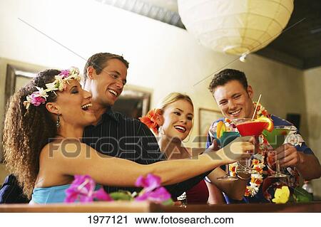 Stock Image - Hawaii, Oahu, Two Flower Bedecked Couples At A Bar.. Fotosearch