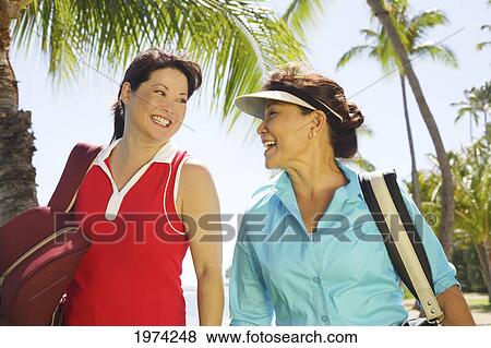 Stock Photo - Hawaii, Oahu, Two Woman Enjoying A Day Of Golf.. Fotosearch