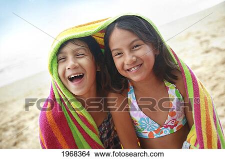 Picture - Hawaii, Oahu, Two Young Girls Wrapped In A Colorful Towel.. Fotosearch