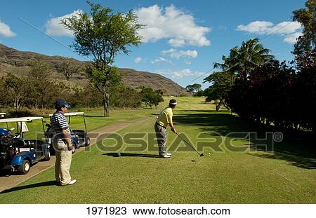 Stock Image - Hawaii, Oahu, Waianae, Makaha Resort, Two Japanese Men Play The 15Th Hole.. Fotosearch