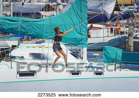 Stock Photography - Hawaii, Oahu, Waikiki, Ala Wai, Woman Raising The Sail On Her Yacht.. Fotosearch