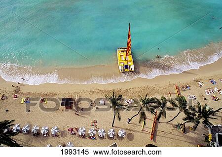 Stock Photography - Hawaii, Oahu, Waikiki Beach With Catamaran, Umbrellas And Vacationers On Beach, View From Above. Fotosearch