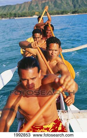 Stock Image - Hawaii, Oahu, Waikiki, Close-Up Of Paddlers In An Outrigger, On Ocean, Diamond Head In Background. Fotosearch